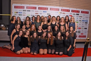 Gruppenfoto mehrerer Personen vor einer Sponsor-/Partnerwand, arrangiert für eine gemeinsame Teamaufnahme in Veranstaltungsumgebung.