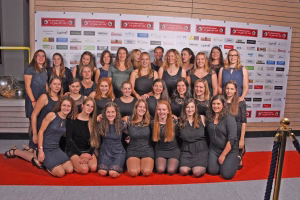 Gruppenfoto von sportlich gekleideten Frauen in zwei Reihen vor einer Sponsorwand, als Team-Sammelbild für Vereinsdarstellung.