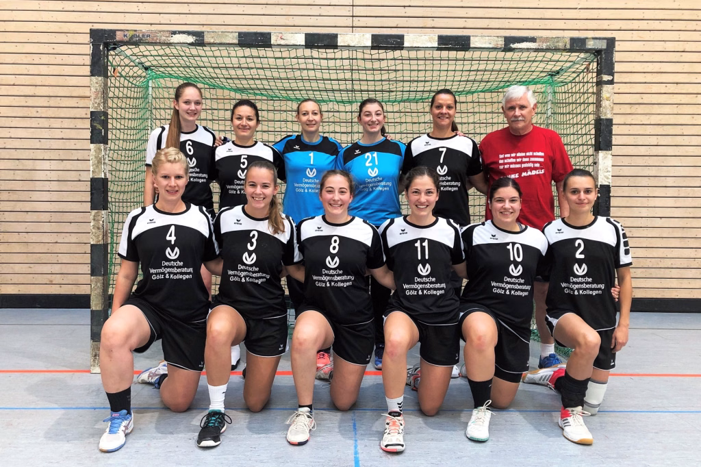 Niederlage trotz Leistungssteigerung für Damen I 5 Handballmannschaft in Sportkleidung posiert vor dem Tor, nummerierte Trikots; Ziel: Teampräsentation.