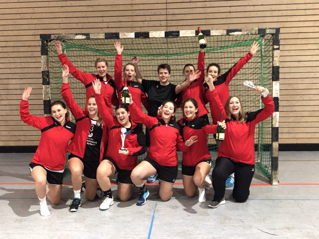 TV Großbottwar sichert sich den Sieg beim Damen-Turnier 9 Mannschaft in Sportkleidung posiert vor einem Handballtor und streckt die Hände nach oben; Trophäe und Siegergruß im Turnierkontext.