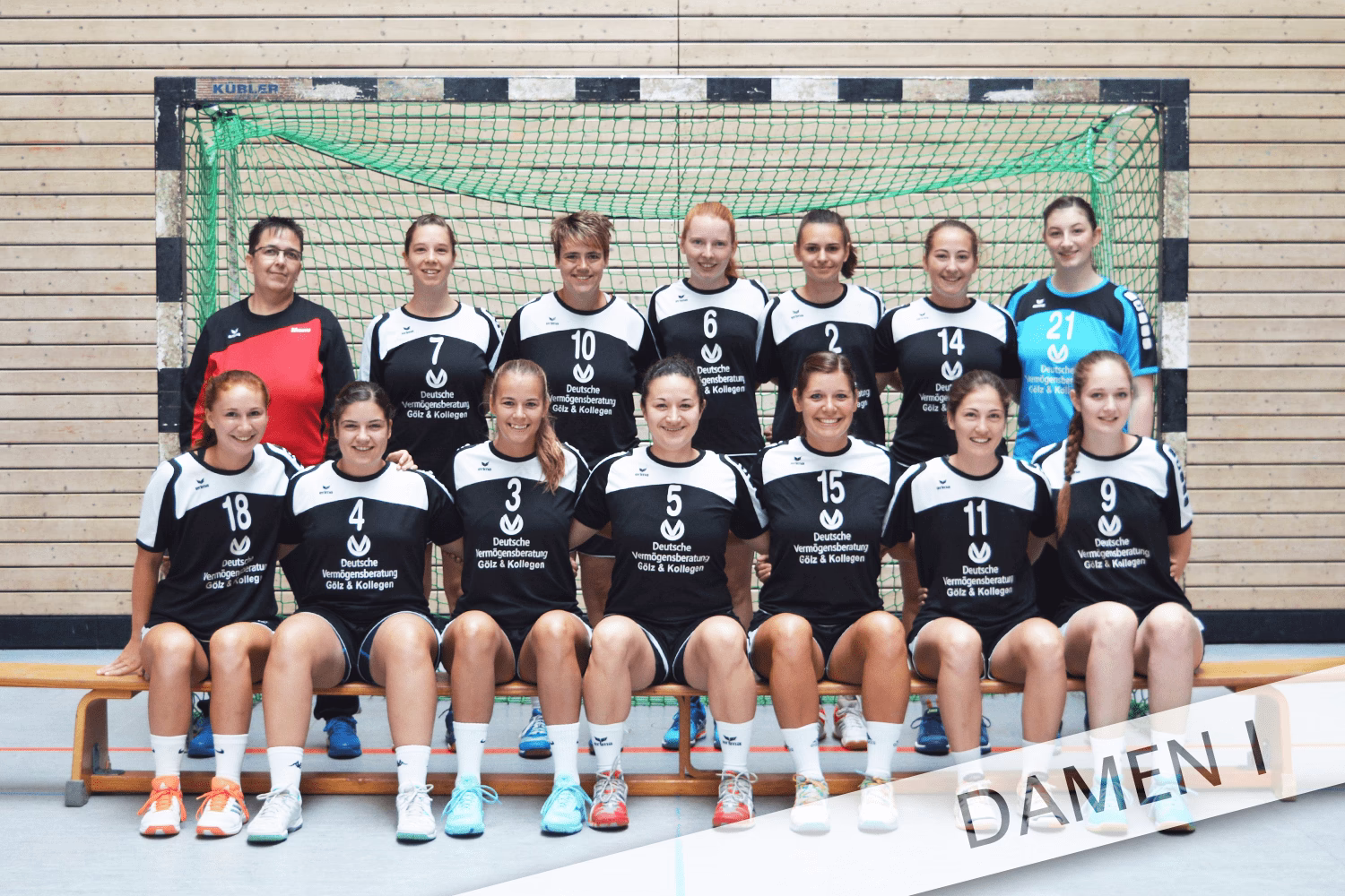 Mannschaftsaufstellung mehrerer Spielerinnen im Sporttrikot vor einem Handballtor, Zahlen auf Trikots, zum Teamfoto.
