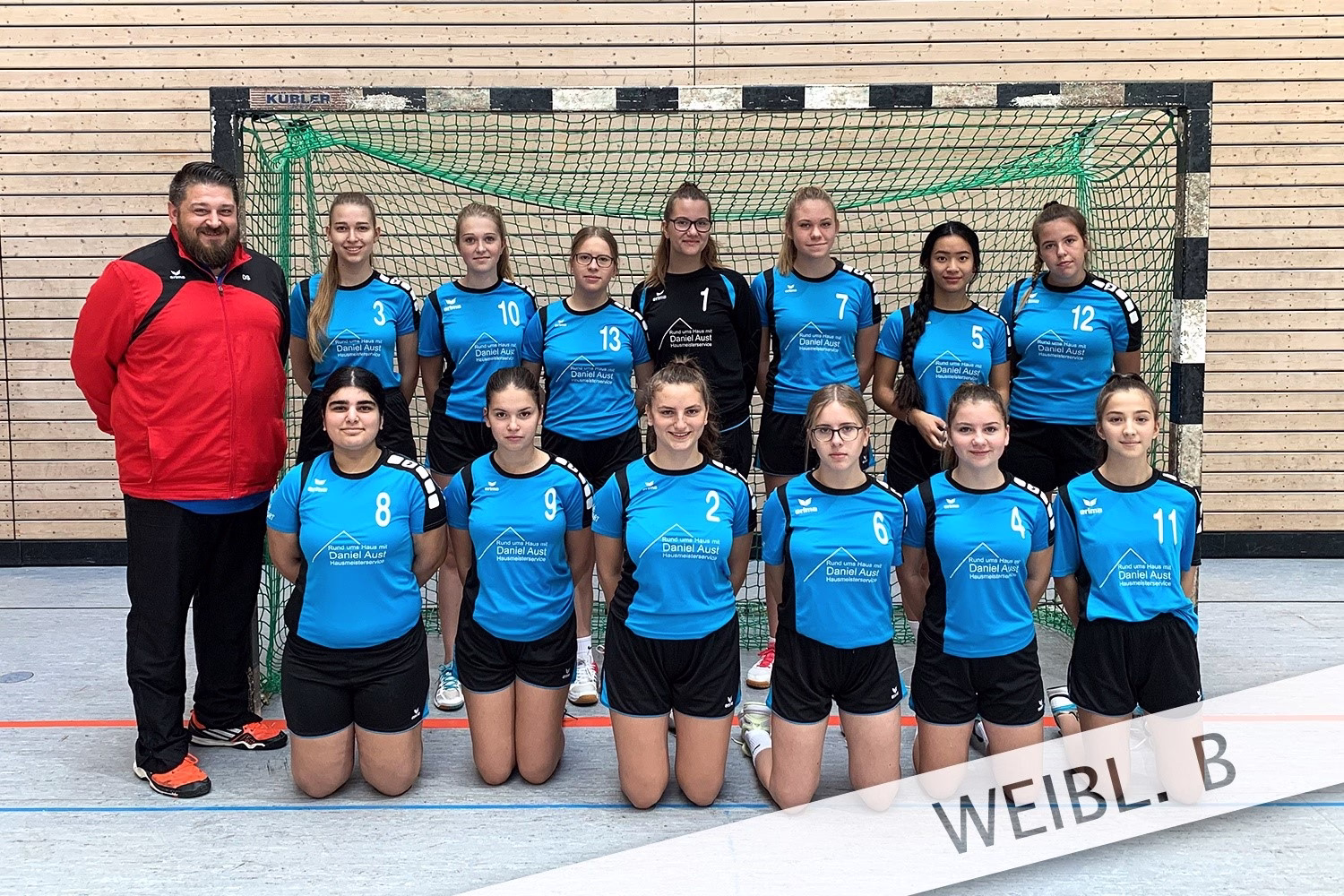 Mannschaftsaufstellung von Handballspielerinnen vor einem Tor in der Sporthalle, als Gruppenfoto vor dem Spiel.