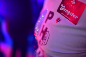 Unscharfes Bild mit rotem und blauem Kontrast, zeigt die Hülle eines Getränkebeutels und die bedruckte Schrift darauf im Party-Licht.