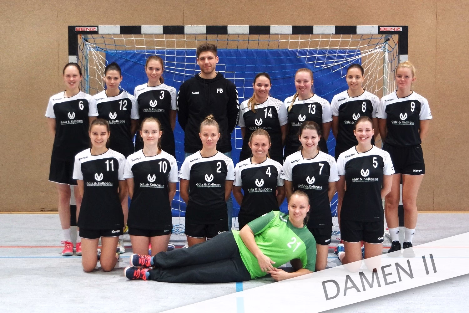 Handballmannschaft steht vor dem Tor, eine Person kniet vorn in grünem Trikot; Teamfoto für Darstellung und Zuordnung.