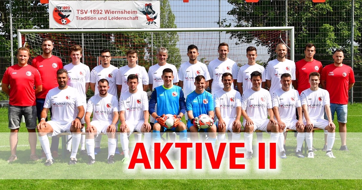 Mannschaftsbild auf Fußballplatz vor Tor: Spieler in Trikots posieren, daneben zwei Trainingsanzüge; große Schrift „AKTIVE II“.