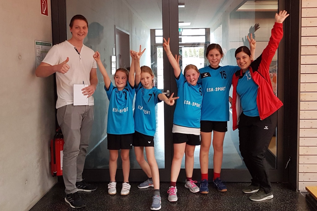 wE-Jugendspieltag mit Happy End 9 Zwei Gruppen von Kindern und Betreuerin im Flur, alle winken und machen Handzeichen vor der Türöffnung.