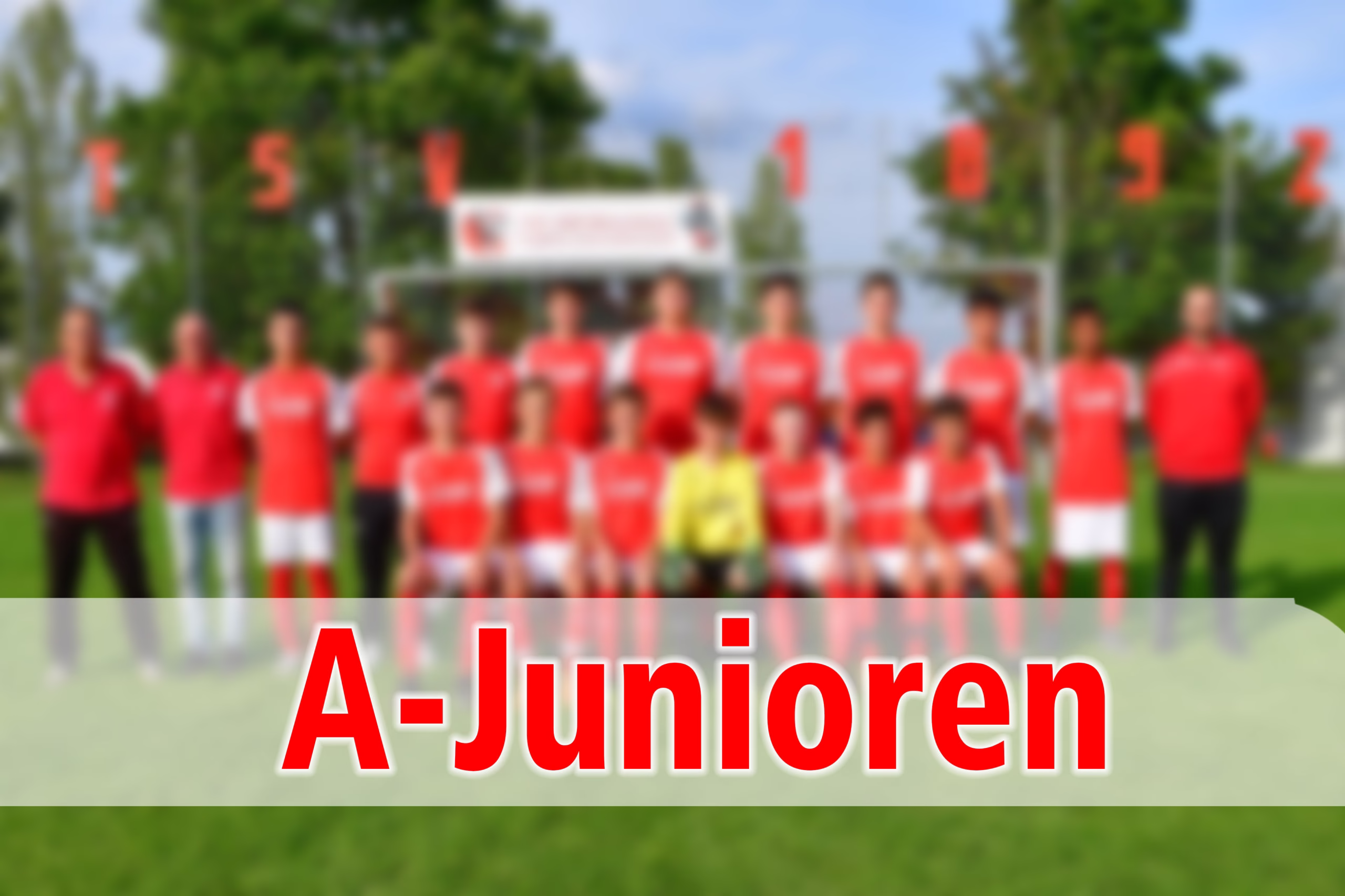 Unscharfe Mannschaftsfotografie von A-Junioren auf Sportplatz, Spieler in roten Trikots mit Banner „A-Junioren“.