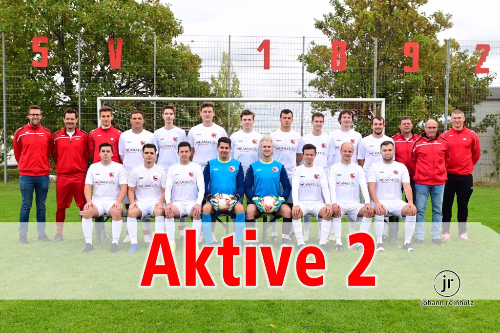 SGM STERNENFELS II/HÄFNERHASLACH II/GÜNDELBACH II - TSV Wiernsheim II 1:2 2 Fußballmannschaft im Gruppenfoto vor Tor und Stacheldrahtzaun, darüber rote Zahlen 5 V 1 8 9 2 sowie Titel „Aktive 2“.